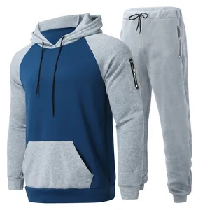 Men's two-piece fleece tracksuit featuring a colorblock drawstring hoodie and gray sweatpants.