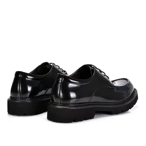 Rear view of glossy black patent leather dress shoes with thick rubber lug soles