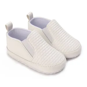 Primer plano de zapatos blancos para bebé con textura tejida y elástico