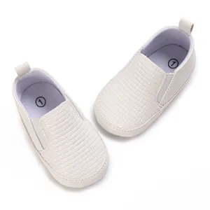 Vista superior de zapatos para bebé tipo slip-on blancos con textura tejida y suela de algodón