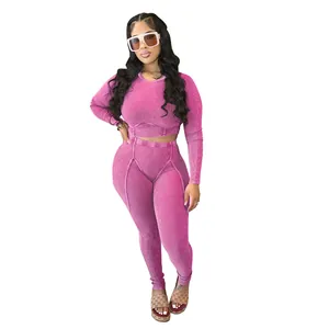 Detailed view of women's pink ribbed two-piece long sleeve crop top and leggings set