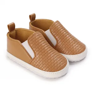 Primer plano de mocasines tejidos para bebé con suelas blancas suaves y antideslizantes
