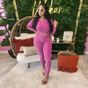 Women's sexy pink ribbed two-piece set with long sleeve crop top and leggings.