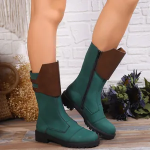 Detailed close-up of green mid-calf knight boots with brown leather panels and side zipper.