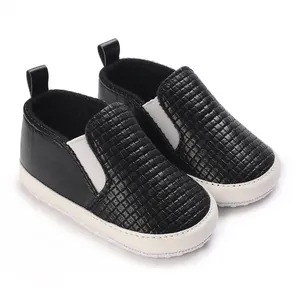 Primer plano de zapatos de bebé tejidos en negro con suelas blancas antideslizantes