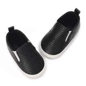 Vista superior detallada de zapatos negros con textura para bebé con suelas blancas antideslizantes