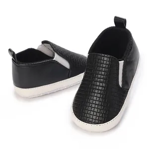 Detalle de zapatos de bebé negros texturizados con suelas de algodón suave antideslizante