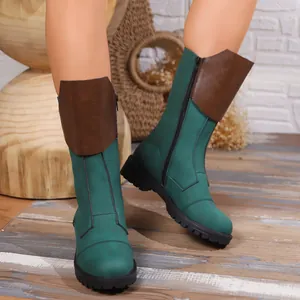 Close-up of stylish green and brown mid-calf boots with side zipper and lug sole