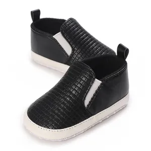 Primer plano detallado de zapatos para bebé negros con punta texturizada y suela blanca