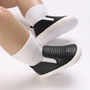 Primer plano detallado de zapatos de bebé tejidos en negro con suela antideslizante.