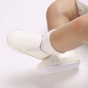 Detalle de zapatos de bebé blancos con textura tejida y suelas de algodón antideslizantes