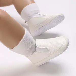 Vista detallada de la textura tejida blanca en zapatos de bebé con suela antideslizante