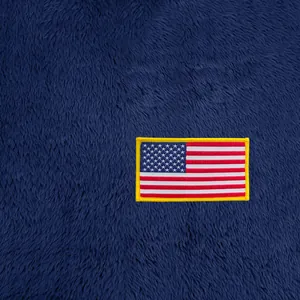 Gros plan du patch drapeau américain sur la texture d'un sweat en polaire bleu marine.