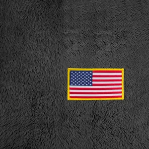 Détail du patch brodé drapeau américain sur le tissu polaire gris du sweat à capuche