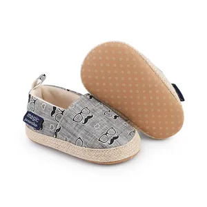 Gros plan sur les chaussures de bébé grises avec motif moustache et semelle antidérapante