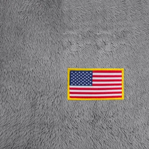 Vue macro détaillée d'un écusson brodé drapeau américain sur tissu polaire gris doux