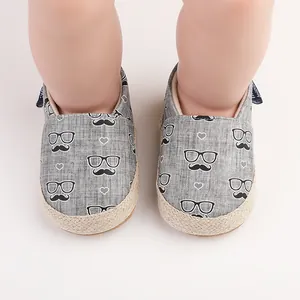 Détail des chaussures de marche pour bébé grises avec imprimé moustache et semelle jute