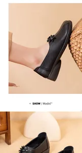 Detalle de bailarinas de cuero negro vintage con adornos florales para mujer.
