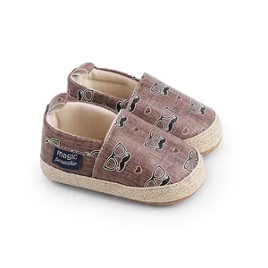 Vue détaillée de chaussures de marche pour bébé marron avec motifs moustaches et lunettes