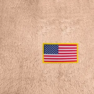 Gros plan d'un écusson brodé drapeau américain sur un tissu de polaire beige doux