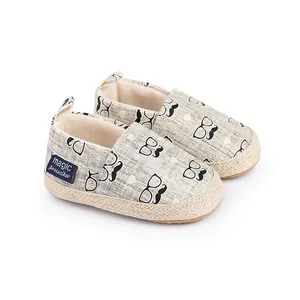 Gros plan chaussures bébé avec imprimé moustaches et lunettes et semelle tressée
