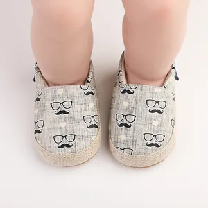 Chaussures bébé avec imprimé moustache et détail de semelle en jute.