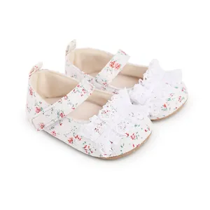 Detail view of floral print baby walking shoes with white lace ruffles and strap