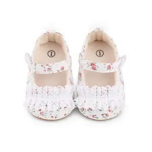 Detailed view of floral baby walker shoes with white lace trim and Velcro straps