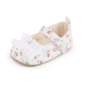 Close-up of floral baby walking shoes featuring white lace ruffles and velcro strap detail