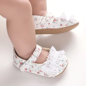 Close-up of adorable baby floral lace walking shoes with white ruffle bow detail and strap