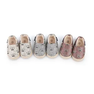 Trois paires de chaussures de marche pour bébé avec motifs moustaches et lunettes.