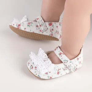 Close-up view of elegant white floral lace baby walking shoes with cute ruffle detail