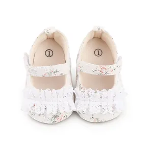 Detail of floral lace baby walking shoes with cute white ruffle trim and strap.