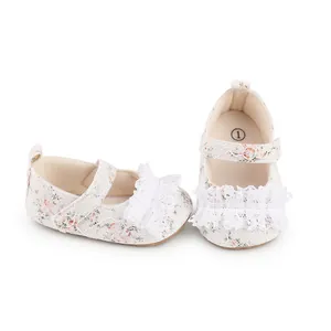 Macro view of white floral lace baby walking shoes with ruffled detail and soft sole