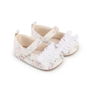 Close-up view of floral lace baby walking shoes featuring a delicate white ruffle bow