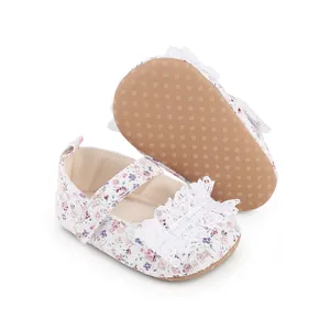 Detailed view of floral infant walking shoes featuring lace trim and non-slip tan soles