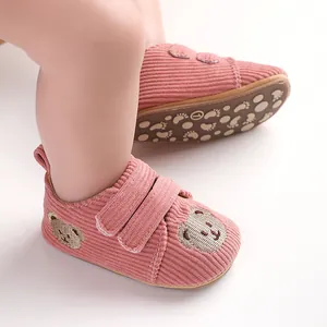 Weiche rosa Baby-Lernlaufschuhe aus Cord mit Bärenstickerei und rutschfester Sohle.
