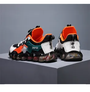 Detailed view of children's sports shoes with rotary buckle and vibrant orange lining