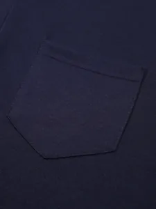 Vista dettagliata della tasca di una polo da uomo blu scuro con doppie cuciture di qualità.