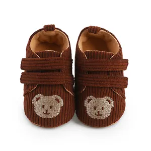 Detailansicht brauner Cord-Lauflernschuhe für Babys mit süßem gesticktem Bärengesicht