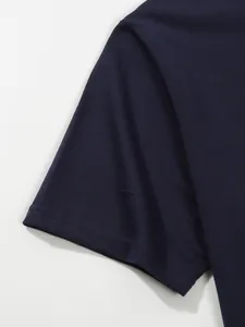 Dettaglio del polsino della manica corta blu scuro di una polo casual da uomo in cotone