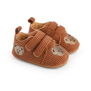 Detailansicht der braunen Cord-Lauflernschuhe für Babys mit süßer Bären-Stickerei-Detail