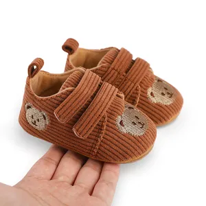 Detailansicht braune Cord-Lauflernschuhe für Babys mit Bärenstickerei und Klettverschluss