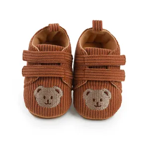 Detailansicht brauner Cord-Lauflernschuhe für Babys mit einer süßer Bärenstickerei