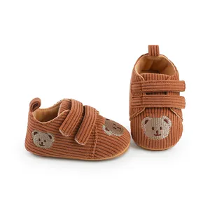 Detailansicht von braunen Baby-Lauflernschuhen aus Cord mit süßer Bärenstickerei
