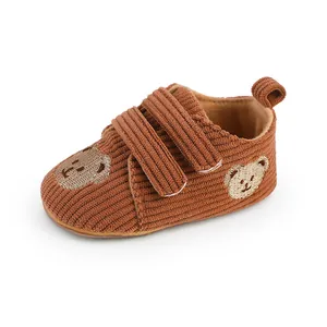 Detailansicht von Baby-Lauflernschuhen aus braunem Cord mit niedlicher Bärenstickerei