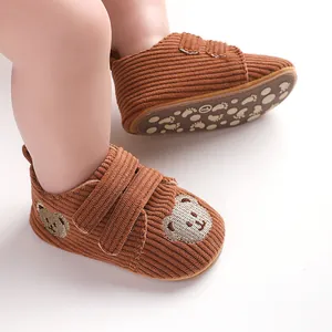 Detailansicht brauner Cord-Babylauflernschuhe mit süßem Bären-Stickerei-Design.