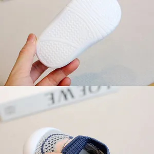 Close-up of anti-slip rubber sole and breathable knitted upper of baby walking shoes.