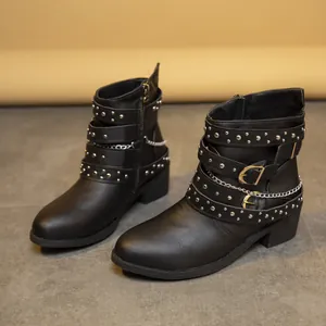Vista detallada de botines negros de estilo gótico con remaches plateados, cadenas y tacón.
