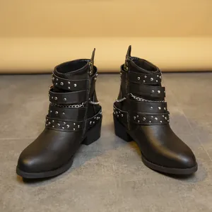 Vista detallada de botas Martin de cuero negro con tachuelas plateadas y correas de hebilla